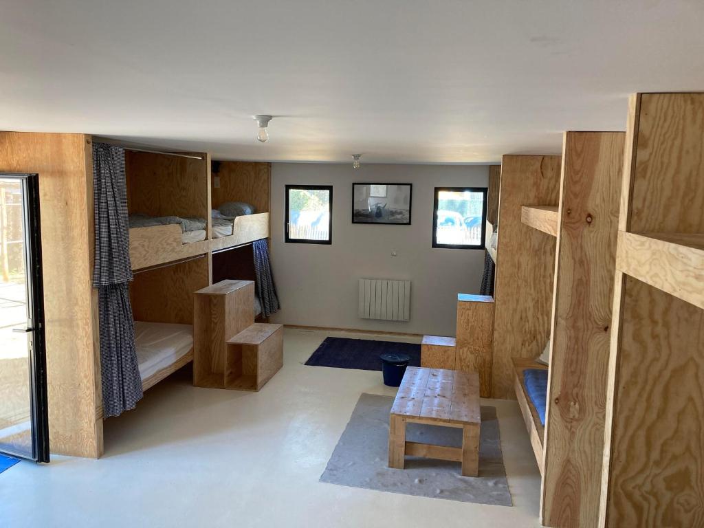 a room with bunk beds and a table at Dortoir de charme 12 lits 600m plage in Longeville-sur-Mer