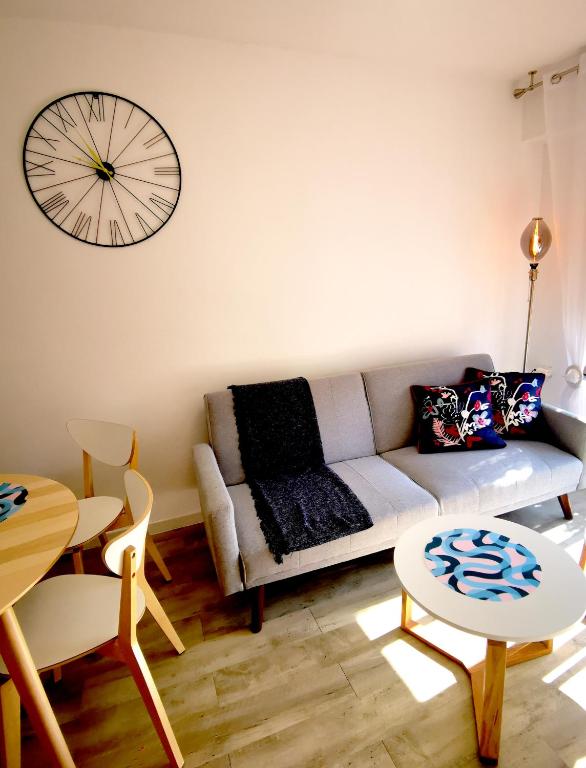a living room with a couch and a clock on the wall at Piso De Balboa Wi-Fi, Air-Con in Gandía