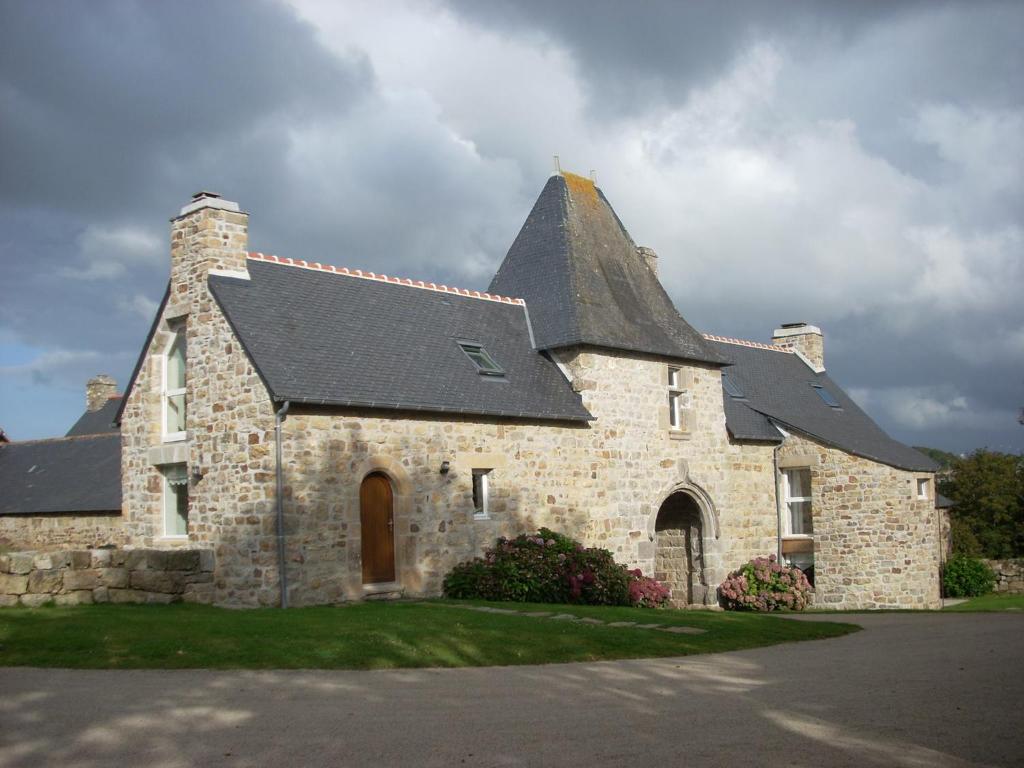een groot stenen gebouw met een zwart dak bij Gîtes du Manoir de Goandour in Crozon