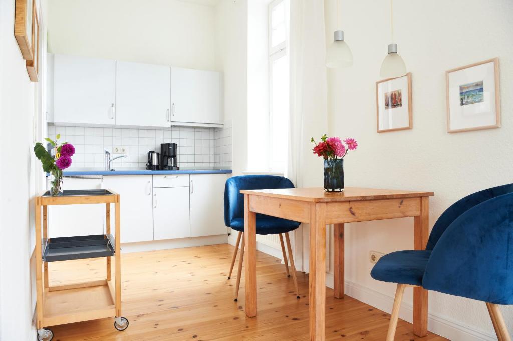 キュールングスボルンにあるAm Angerのキッチン(木製テーブル、青い椅子付)