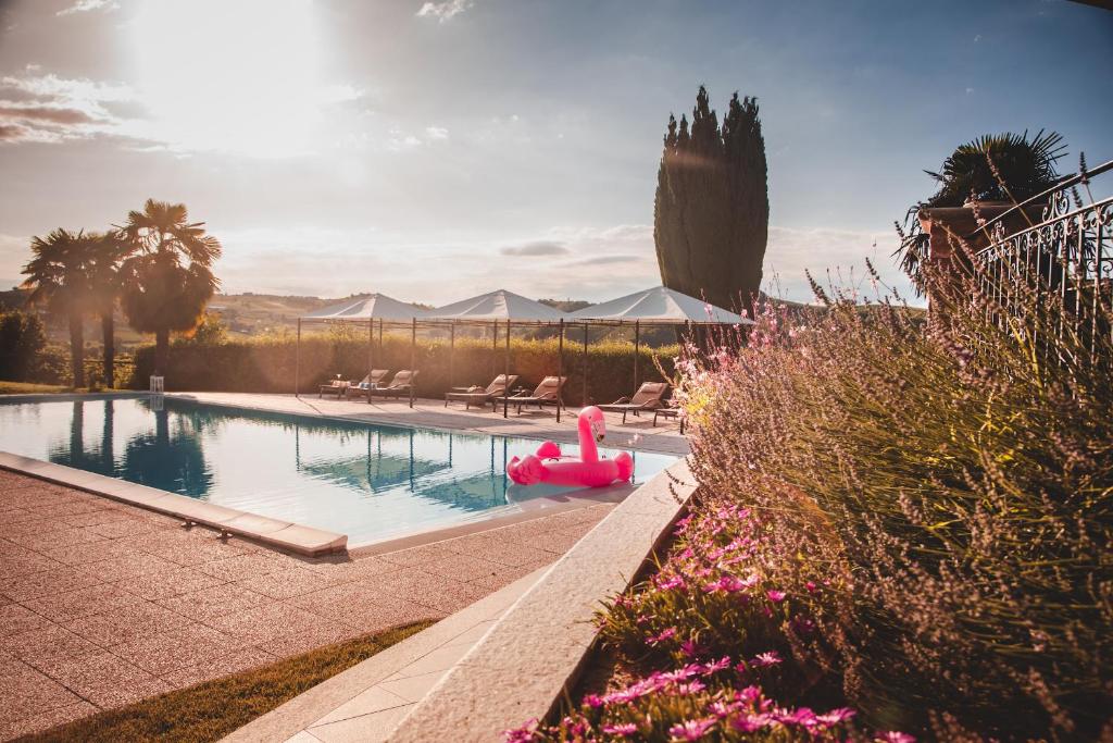 uma piscina com um carro alegórico cor-de-rosa num quintal em Relais Almaranto em Calamandrana