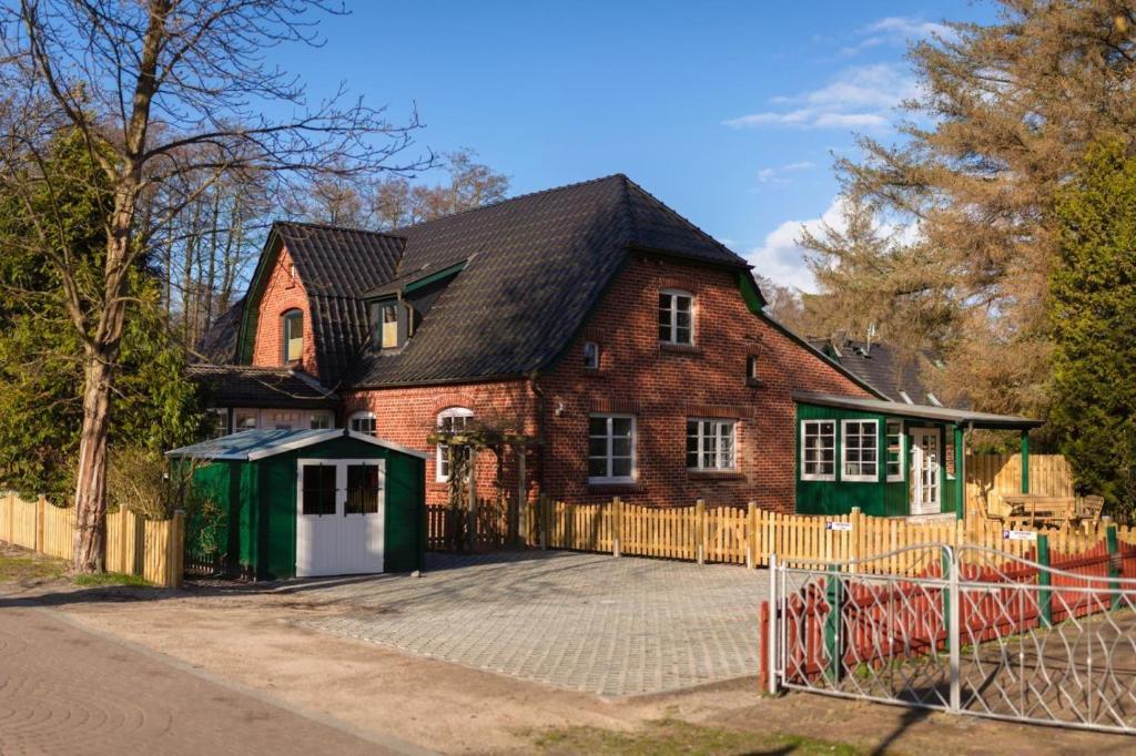 una gran casa de ladrillo con una valla delante de ella en FeWo-Prerow, en Prerow