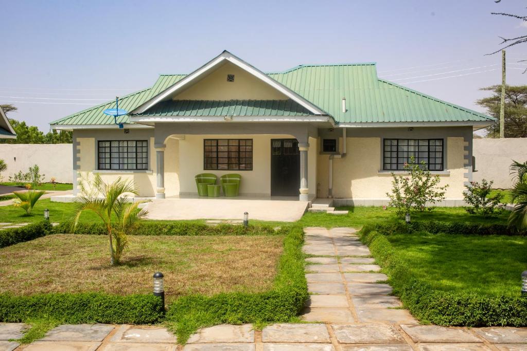 Biały dom z zielonym dachem w obiekcie Lodwar Acacia Residences w Lodwar