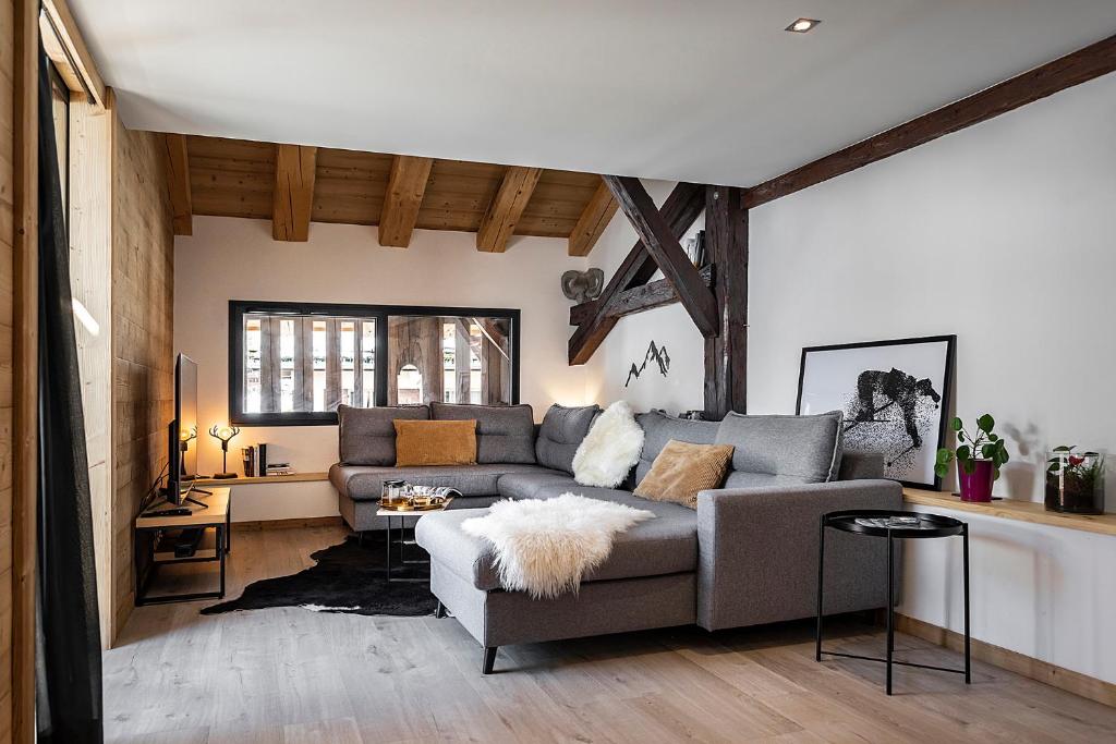 uma sala de estar com um sofá e uma mesa em Spacieux duplex avec vue em La Clusaz
