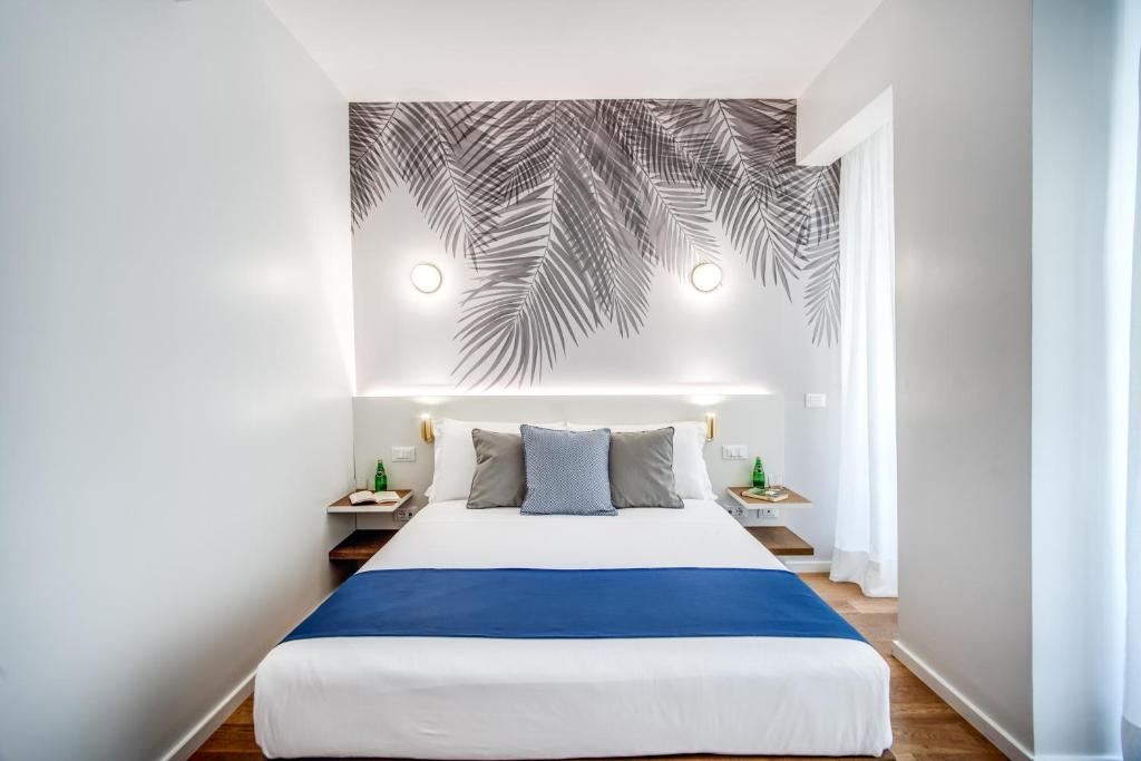 a bedroom with a bed and a palm tree mural at Victor Boutique Hotel in Milan