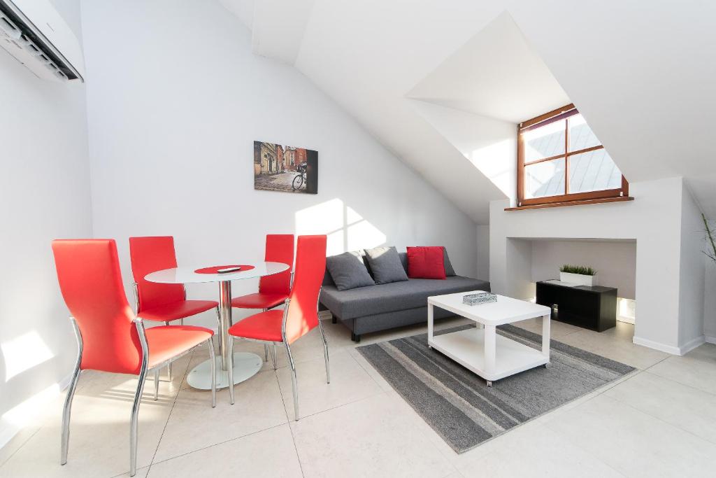 een woonkamer met een tafel en rode stoelen bij Exclusive Loft in the Main Square A/C p4you pl in Krakau