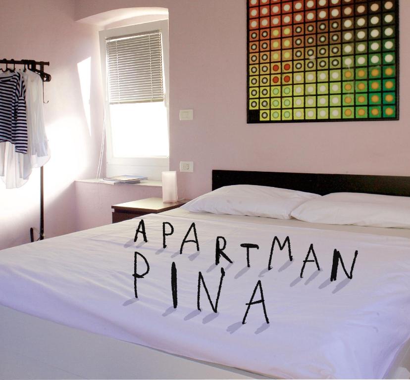 a bedroom with a white bed with the words parramanian immigrant at Hana place in Motovun