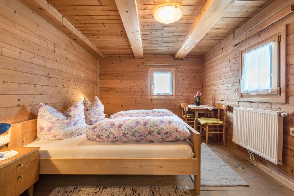 a bedroom with two beds in a wooden room at Ferienwohnung Krösshof in Sarntal