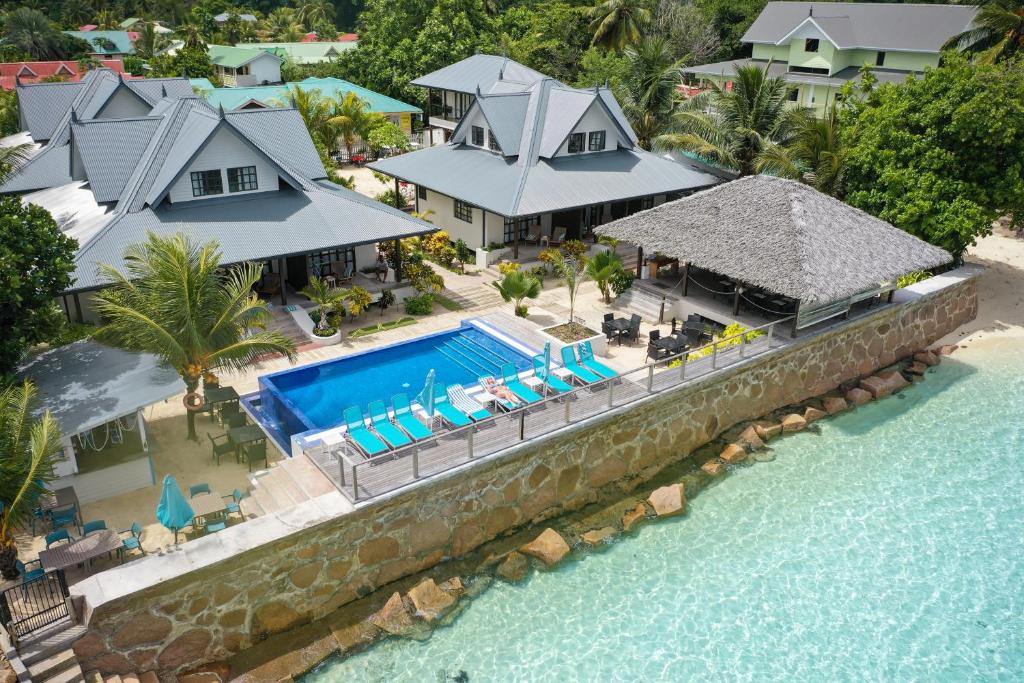 eine Luftansicht eines Hauses mit Pool in der Unterkunft Le Nautique Waterfront Hotel La Digue in La Digue