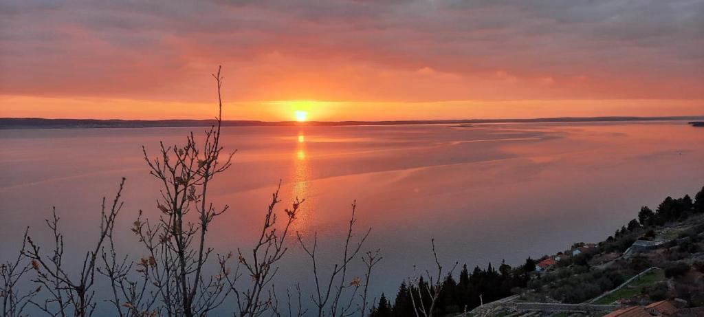 a sunset over a large body of water at Apartmani QUATTRO in Starigrad