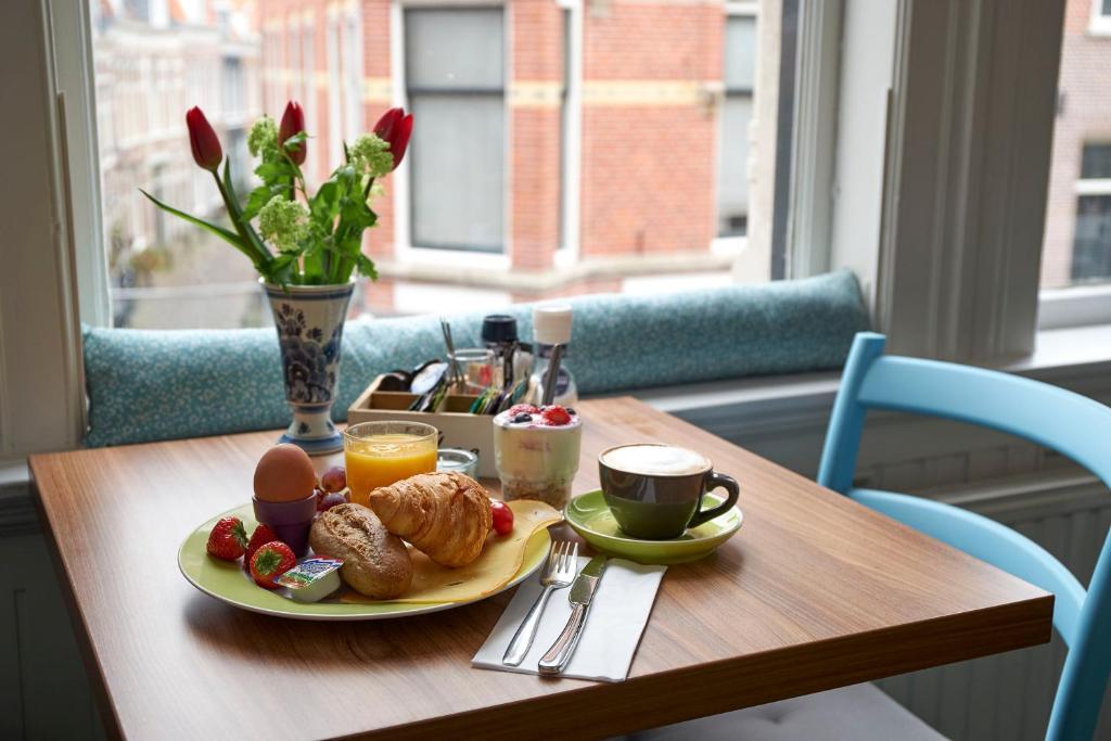 a table with a plate of breakfast food on it at Bed & Breakfast Hotel Malts in Haarlem