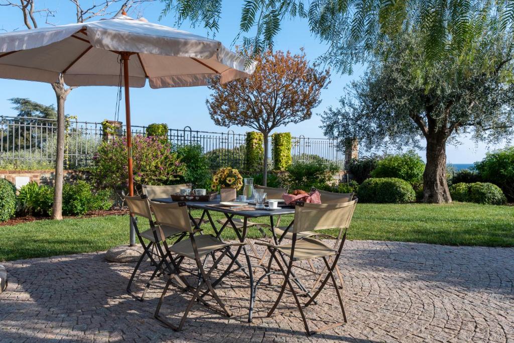 a table and two chairs under an umbrella at Villa Rosmarino in Imperia