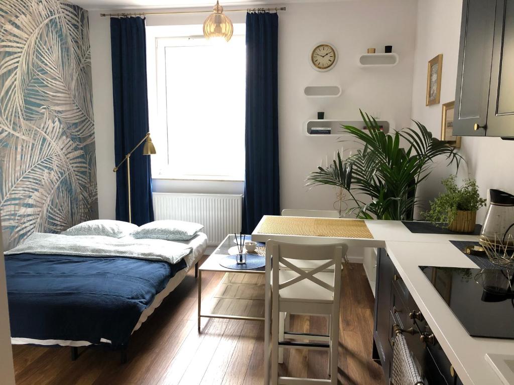 uma sala de estar com uma cama e uma mesa em Blue Dior Apartment Warsaw em Varsóvia