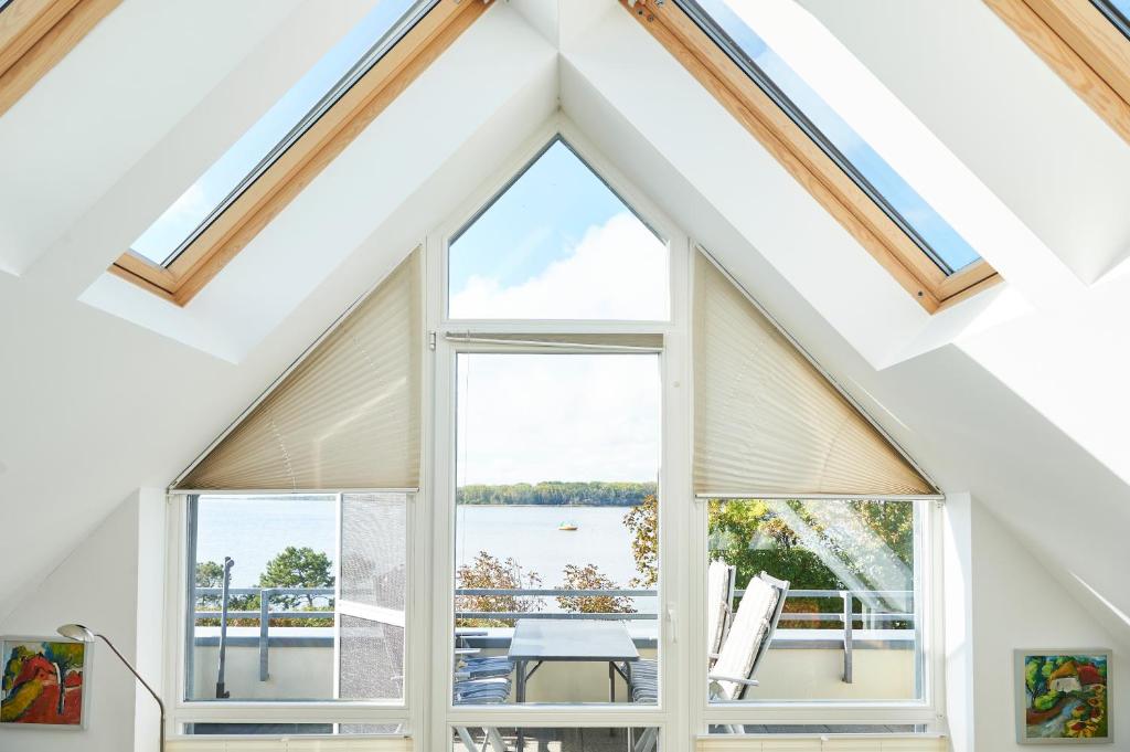 a room with windows and a view of the water at Haffblick Rerik in Rerik