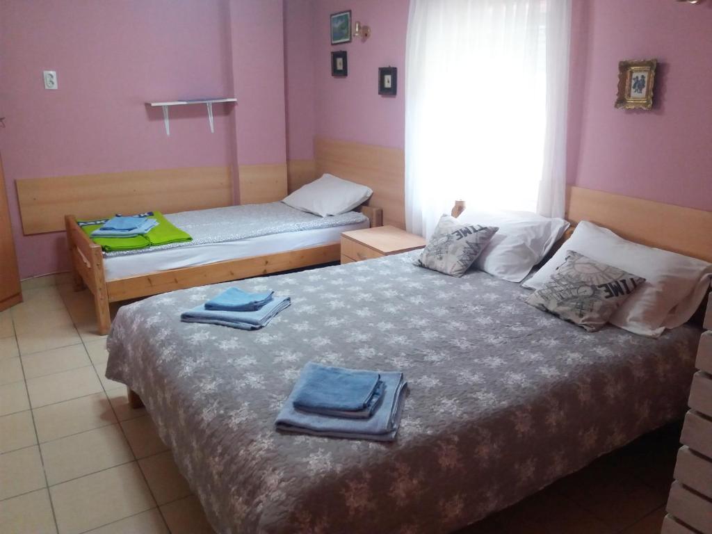 2 Betten in einem Zimmer mit Handtüchern darauf in der Unterkunft Vila Verona Sobe in Palić