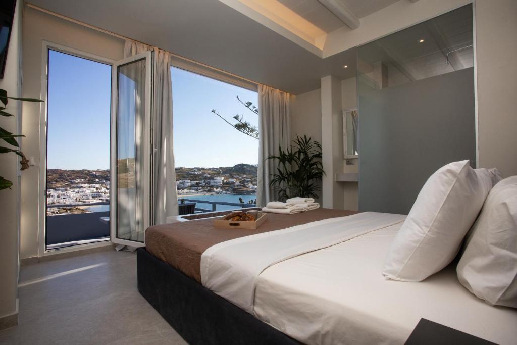 a bedroom with a large bed with a large window at Villa il Sole di Juljan in Mikonos