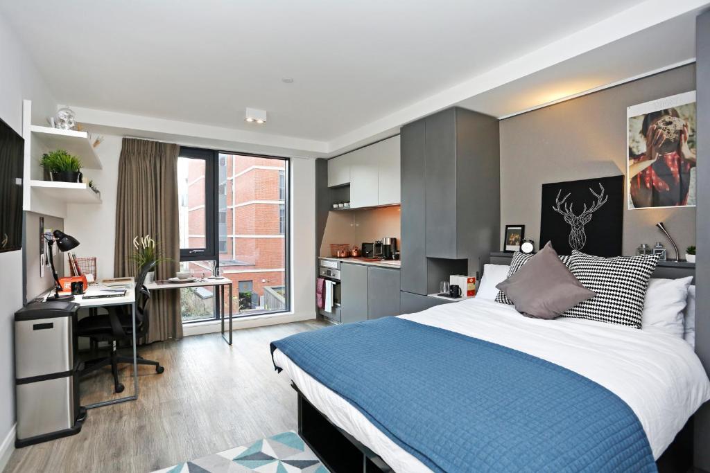 1 dormitorio con cama, escritorio y cocina en ALTIDO at VITA Fountainbridge - Adults only en Edimburgo