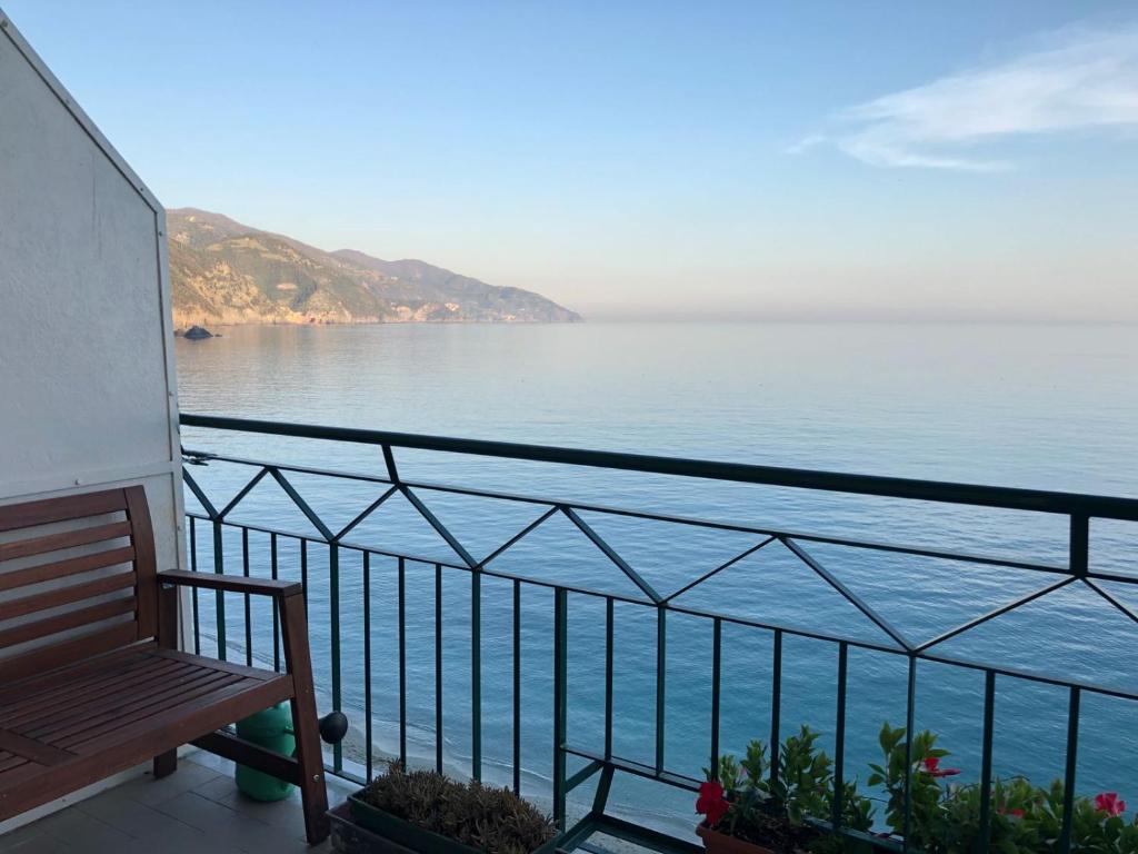 una panchina seduta su un balcone affacciato sull'acqua di Bea's Apartment - The window to the sea - Seafront a Monterosso al Mare