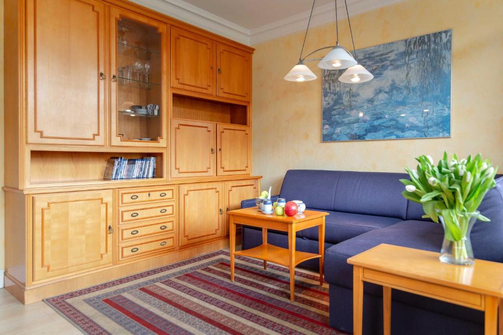 ein Wohnzimmer mit einem blauen Sofa und einem Tisch in der Unterkunft App.Evans in List