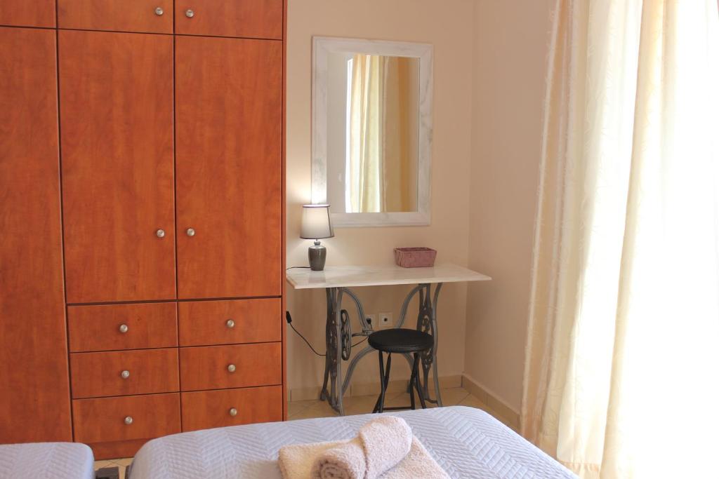 1 dormitorio con cama, escritorio y espejo en Konomi Residence, en Karavádhos