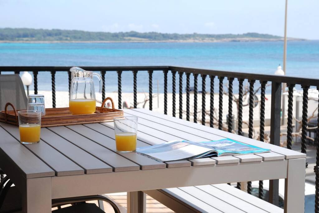 una mesa de picnic con dos vasos de zumo de naranja en Beach house S'Illot en S'Illot