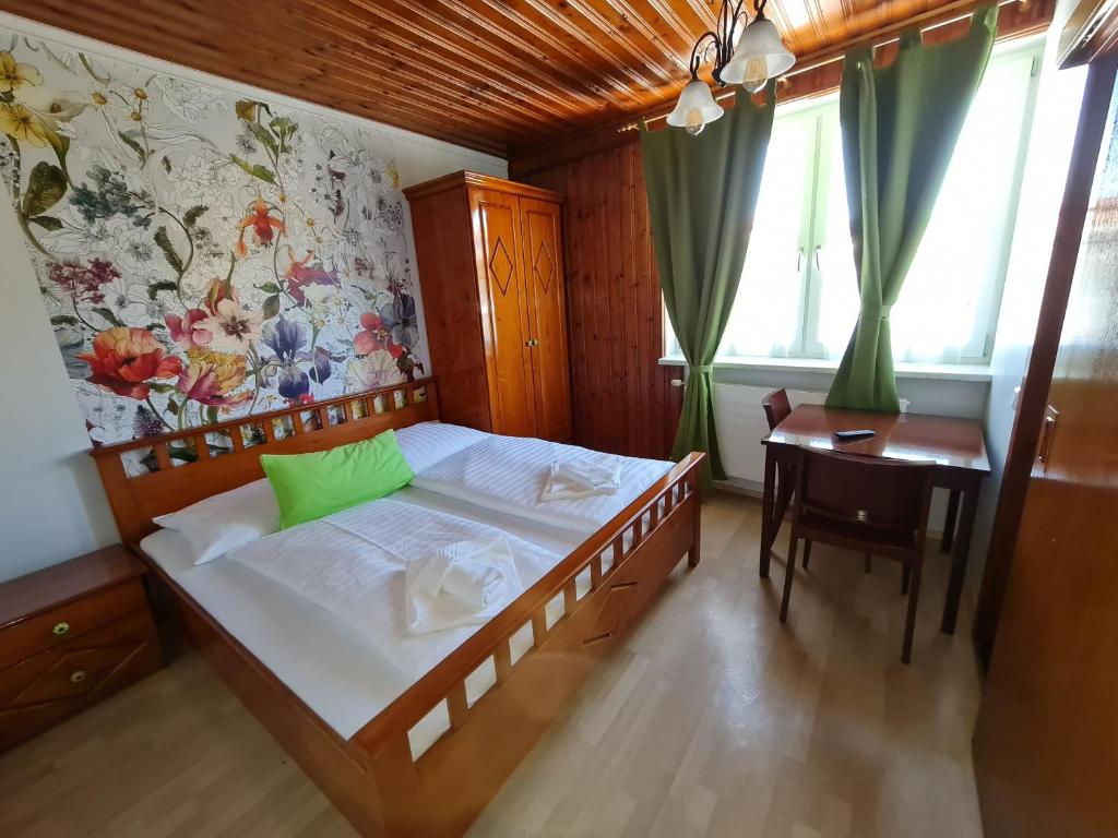 Schlafzimmer mit einem Bett, einem Schreibtisch und einem Fenster in der Unterkunft Vita Gasthof in Rastenfeld