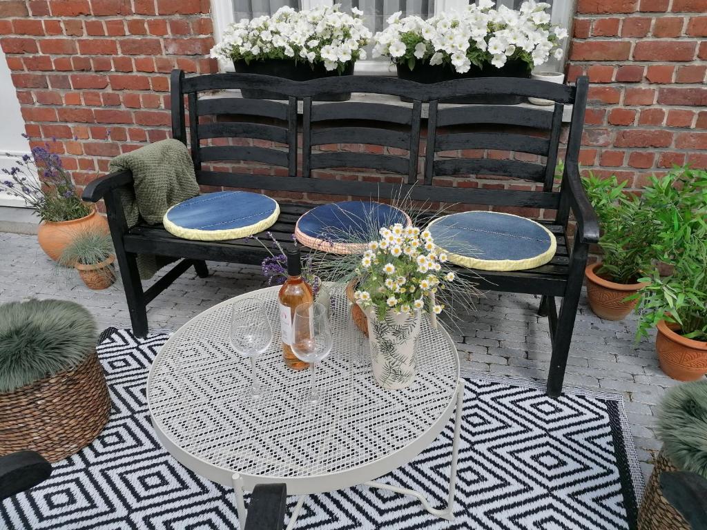 イーペルにあるNellyのガラステーブル(椅子2脚付)、花が咲くパティオ