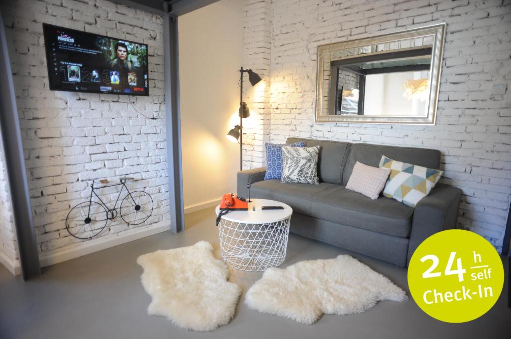 a living room with a couch and a brick wall at Micro Loft Central in Unirii in Cluj-Napoca