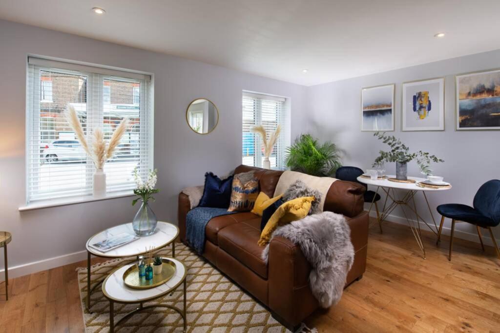 sala de estar con sofá marrón y 2 mesas en Roseland Apartment 1, en Arundel