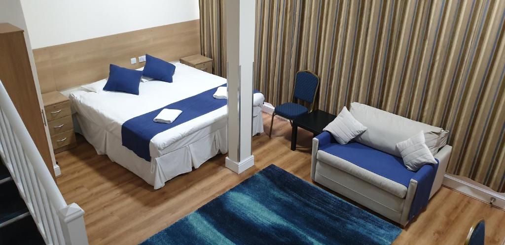 a hotel room with a bed and a chair at PremierLux Serviced Apartments in Ilford