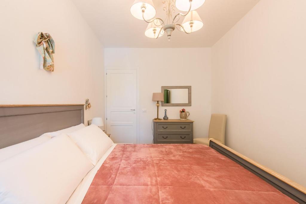 a bedroom with a bed and a chandelier at Villa Cinzia-150 mt from the beach in Mondello