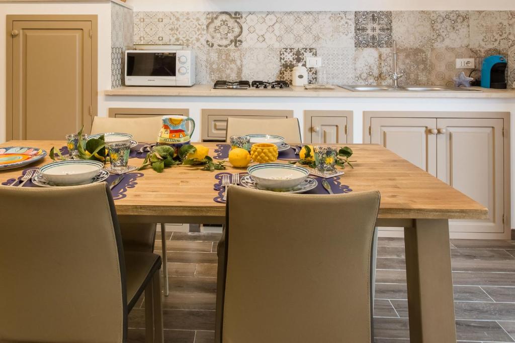 a kitchen with a wooden table with chairs and a tableablish at Villa Cinzia-150 mt from the beach in Mondello