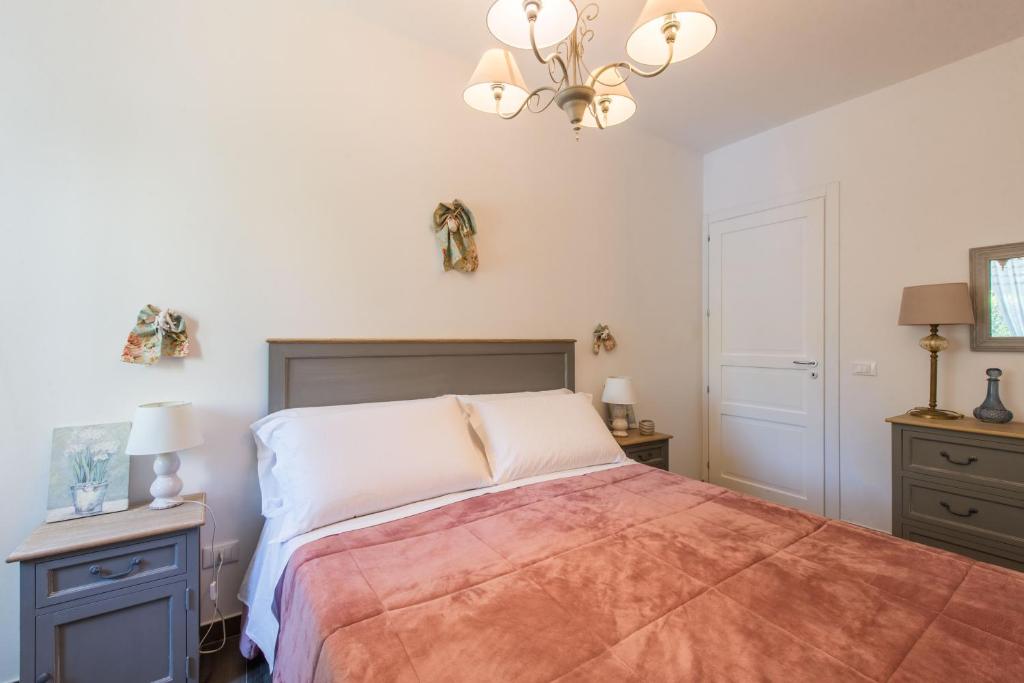 a bedroom with a large bed and a chandelier at Villa Cinzia-150 mt from the beach in Mondello