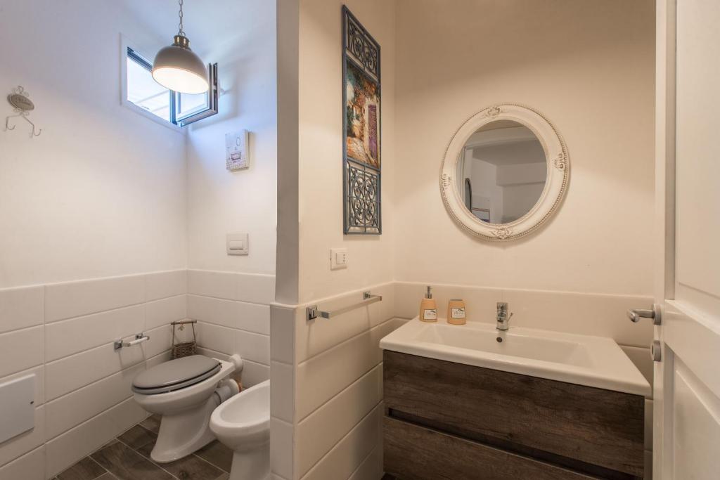 a white bathroom with a toilet and a sink at Villa Cinzia-150 mt from the beach in Mondello