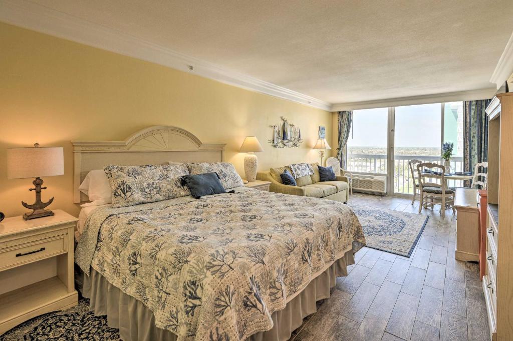 a bedroom with a large bed and a balcony at Daytona Beach Resort Studio with Ocean View and Pools! in Daytona Beach