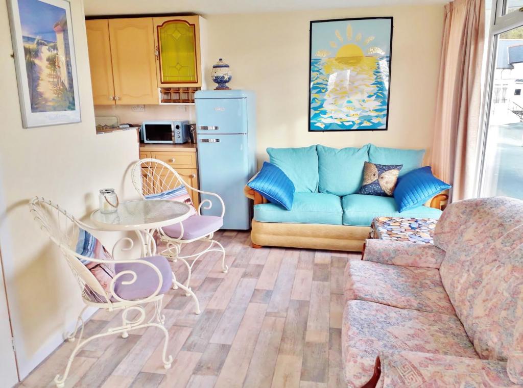 a living room with a couch and a table at Sea Moss Cabin in Tywyn