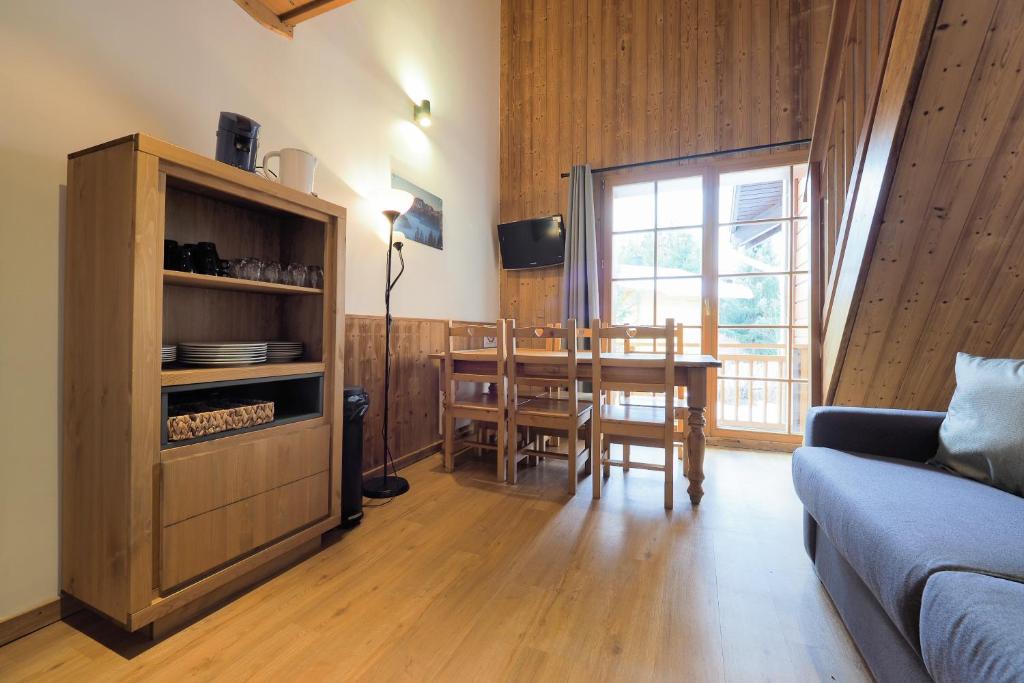 a living room with a table and a dining room at Résidence Aiguille Lodge in Les Deux Alpes