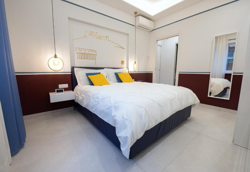 a bedroom with a large bed with two yellow pillows at Napoli City Center - Appartamenti e Camere in Naples