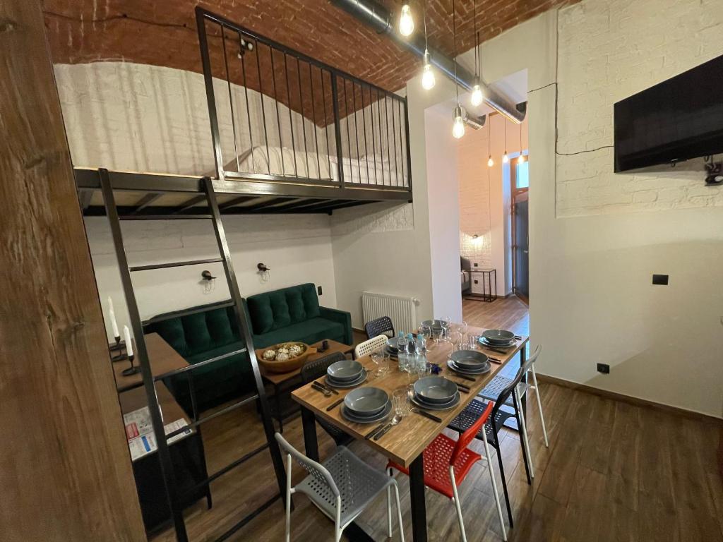 a dining room with a table and some green chairs at ApartmentSun Loft Factory in Wrocław