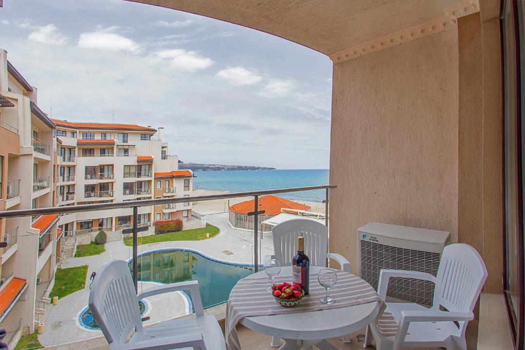 balcón con mesa, sillas y vistas al océano en Sea view Obzor Beach apartment en Obzor