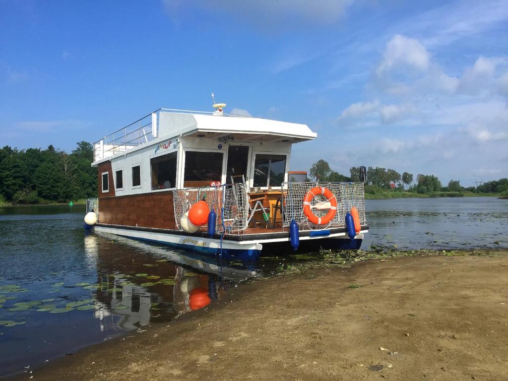 a boat is docked on the water at HOUSEBOAT Mazury Frajda in Giżycko