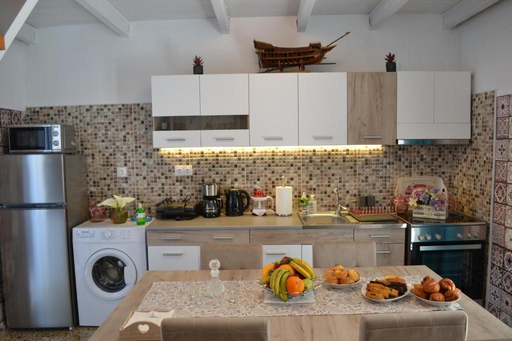 a kitchen with a table with bowls of fruit on it at Michalis Captain Home in Agia Galini