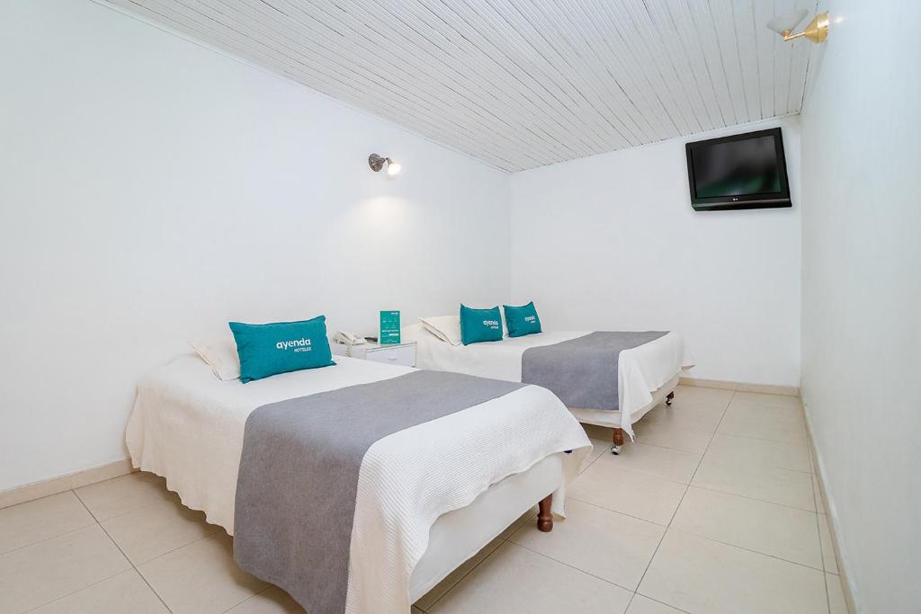 Postel nebo postele na pokoji v ubytování Hotel Calle 112