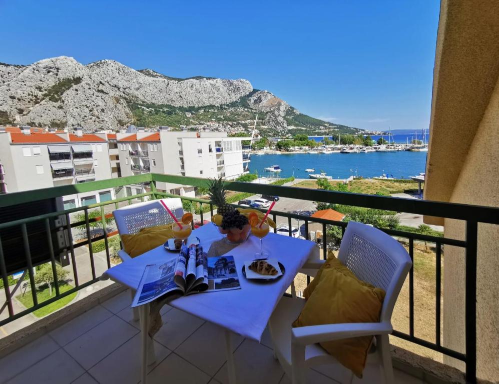 een tafel met een bord eten op een balkon bij Olmissum rooftop sea view in Omiš