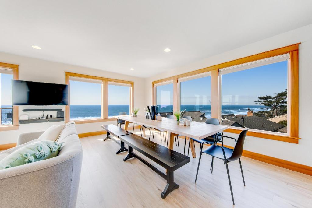 a living room with a dining room table with a view of the ocean at Blue Wave Heights in Lincoln City