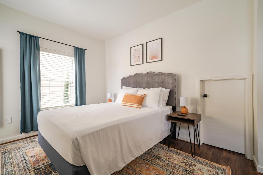 a white bedroom with a large bed and a window at Unit 1 - Spacious & Renovated Apt Home in the City's Action in Houston