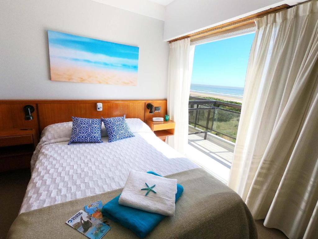 a bedroom with a bed with a view of the ocean at SolMar in San Clemente del Tuyú