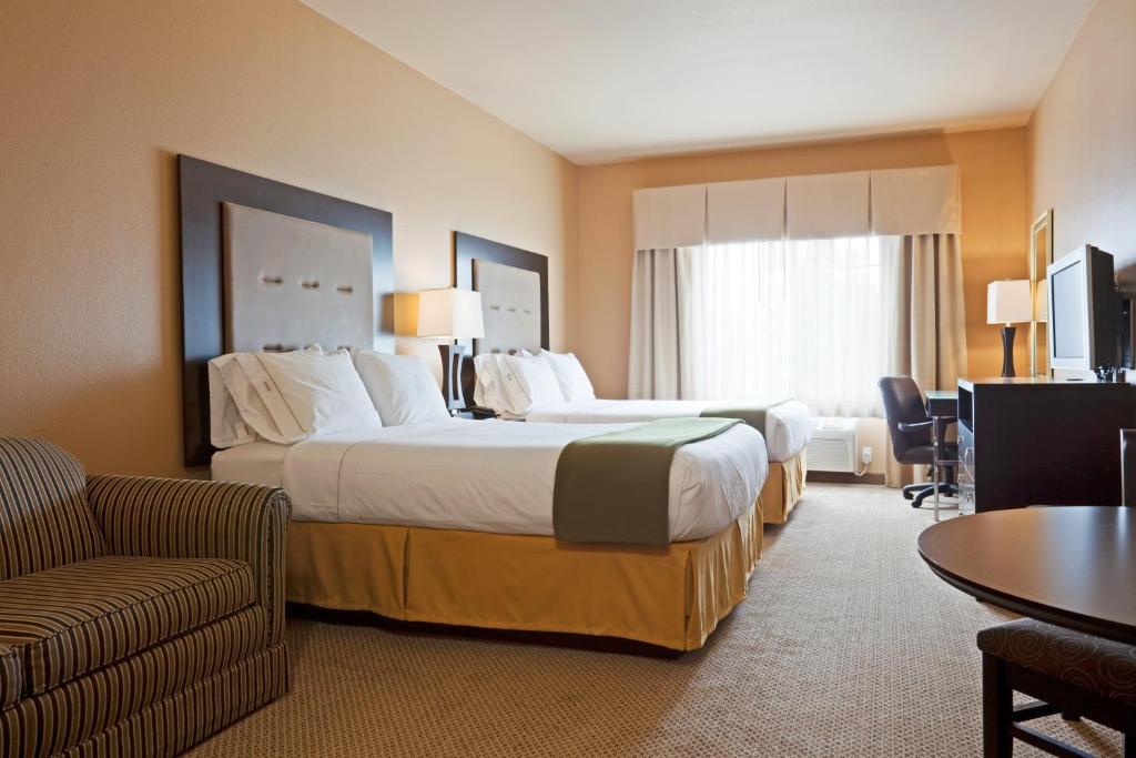 a hotel room with two beds and a couch at Holiday Inn Express Hotel & Suites Eau Claire North, an IHG Hotel in Lake Hallie