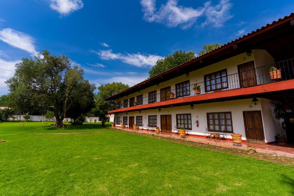 a building with a green lawn in front of it at Hostería San Felipe in Pátzcuaro