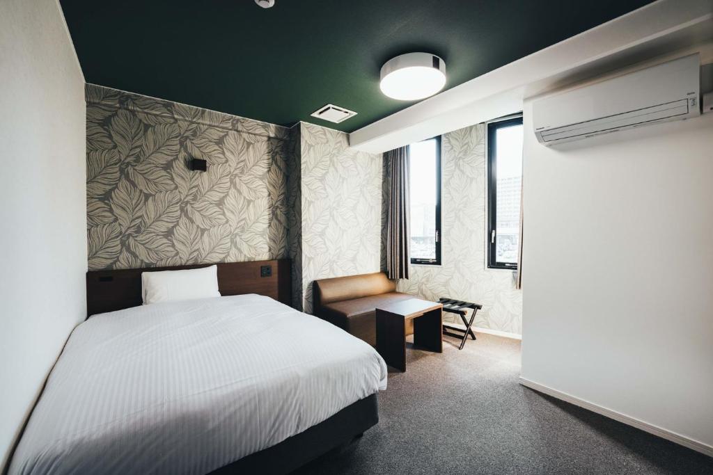1 dormitorio con 1 cama blanca y 1 silla en TAPSTAY HOTEL - Vacation STAY 35036v, en Saga